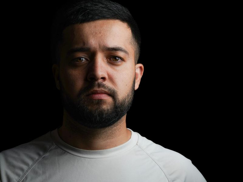 Close up of a person exercising in a dark studio.
